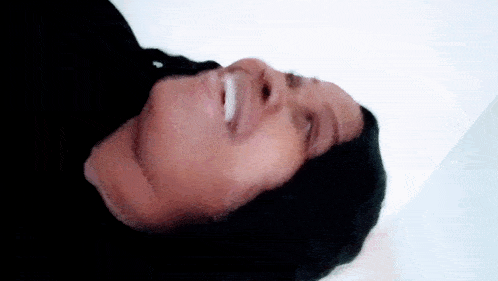 a close up of a person 's face with a white object in their mouth .