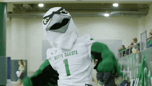 a mascot for north dakota wears a white and green jersey