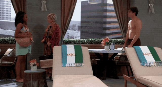 a man stands in front of two lounge chairs with a towel that says mic