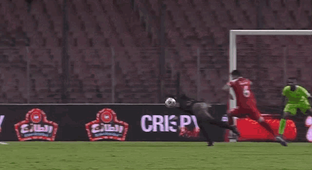 a soccer player with the number 4 on his shirt is diving for the ball