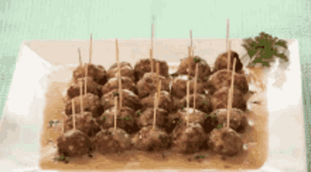 a white plate topped with meatballs on sticks