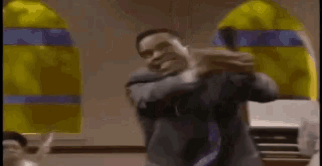 a man in a suit and tie is dancing in front of a microphone .