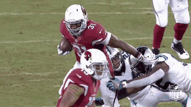 a football player for the cardinals is being tackled by another player