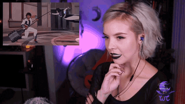 a woman wearing headphones looks at a screen with a man playing a keyboard