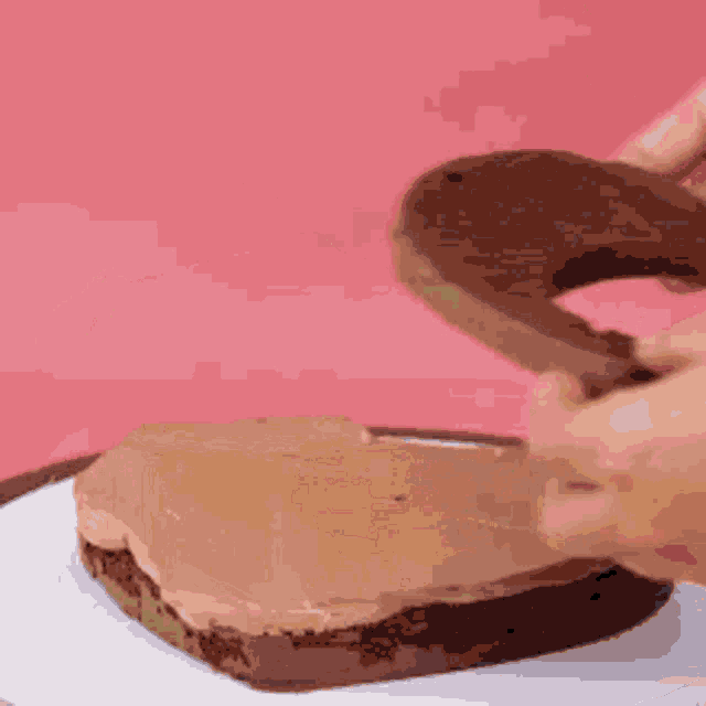 a person is cutting a piece of chocolate cake into the shape of a letter s