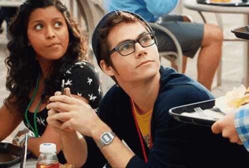 a man wearing glasses is sitting at a table with a girl