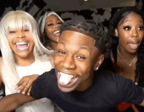 a group of people are laughing and making funny faces while standing next to each other .