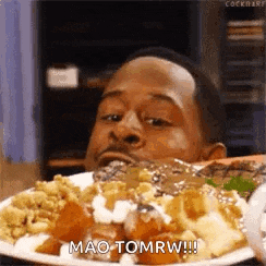 a man is eating a plate of food and saying mao tomrw !