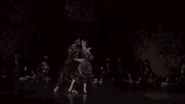 a man and a woman are dancing together on a stage in a dark room .