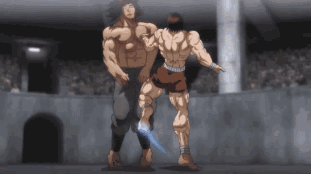 two muscular men are standing next to each other in a ring .