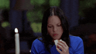 a man with a bandana on his head is eating a sandwich next to another man