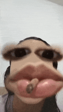 a woman is making a funny face with her mouth open and a worm in her mouth .