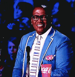 a man in a blue suit and tie is holding a coca cola packet