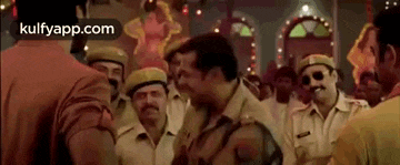a group of police officers are standing in a room .