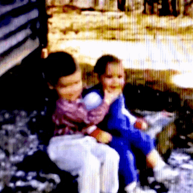 a blurry picture of two children sitting on a bench