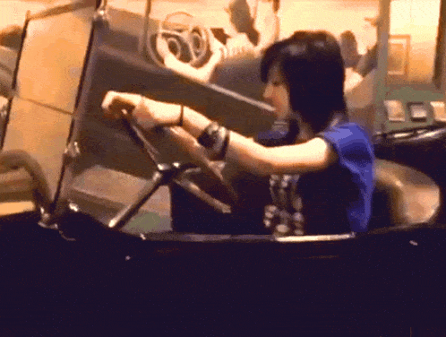 a woman in a blue shirt is driving a car with the number 60 on the windshield