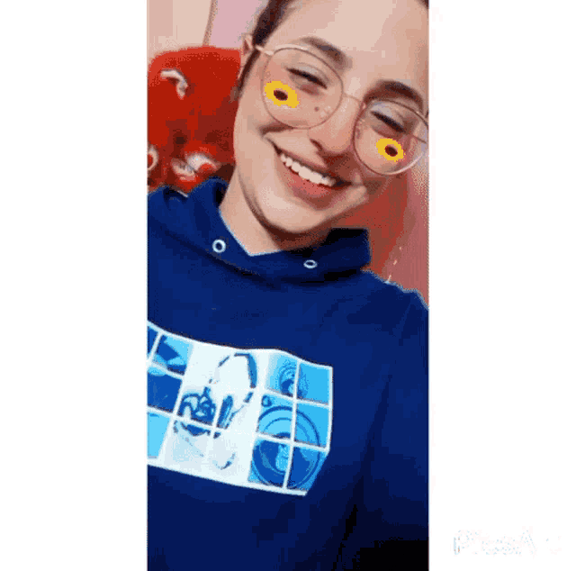 a young woman wearing glasses and a blue hoodie is smiling .