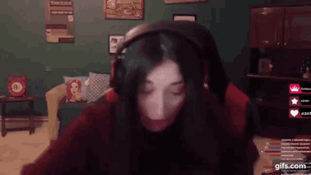 a woman wearing headphones is sitting in a chair in front of a computer screen .