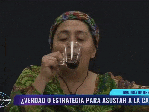 a woman with braces on her teeth sits in front of a tv screen that says brujeria de jenn