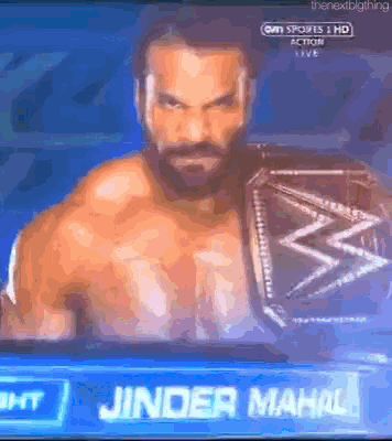 a man with a beard is wearing a wrestling championship belt and is on a tv screen