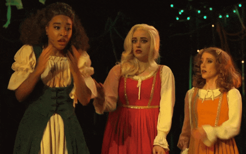three women in costumes are standing next to each other