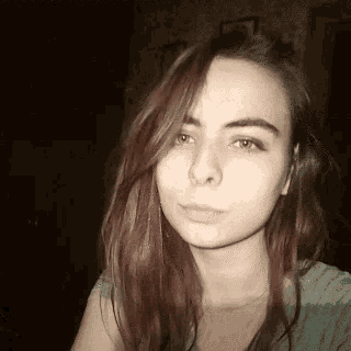 a woman with long red hair is taking a selfie with her eyes closed .