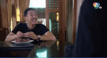 a man sitting at a table with a plate of food in front of him that says hd on the bottom