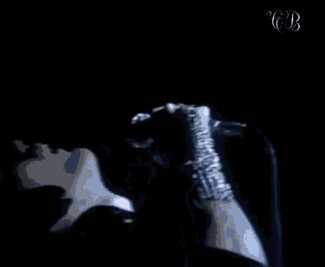 a man is singing into a microphone with a glove on his hand .