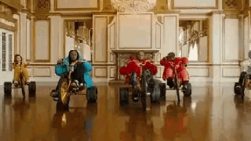 a group of men are riding go karts in a living room .
