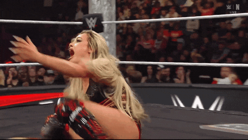 a woman in a wrestling ring with a w logo on the ring