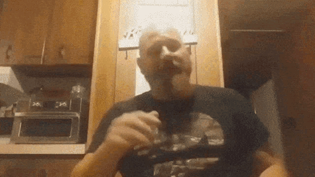 a man with a beard is wearing a black shirt with a picture of a woman on it