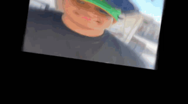 a blurry picture of a man wearing a green hat and sunglasses