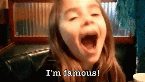 a little girl with her mouth open and the words i 'm famous behind her