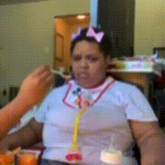 a woman wearing a stethoscope is being fed by a man