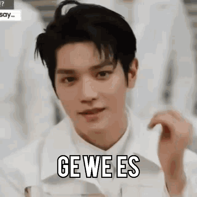 a close up of a young man wearing a white jacket and a white shirt with the words `` ge we es '' written on it .