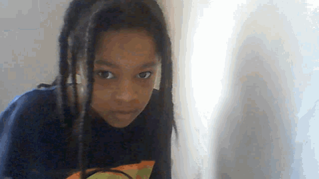 a young girl with dreadlocks wearing a blue shirt