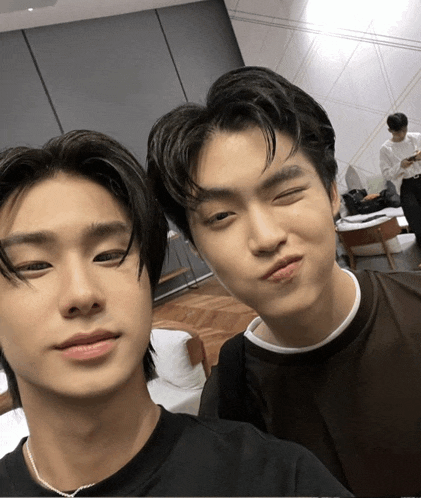 two young men are posing for a picture and one is making a face