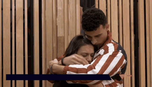 a man in an american flag jacket holds a woman in his arms