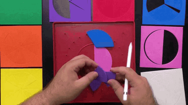a person is holding a purple piece of paper in front of a red board