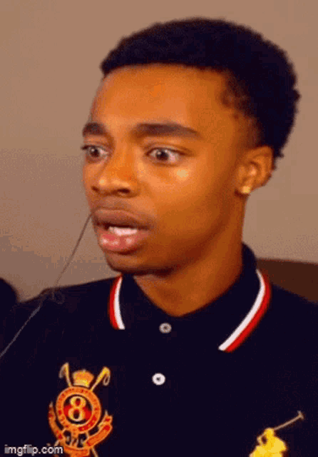 a young man is wearing a black polo shirt with the number 8 on it