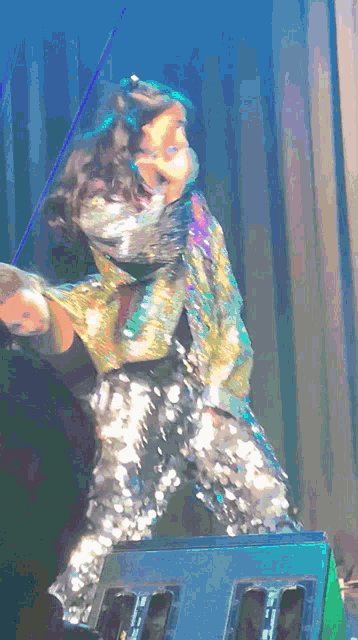 a woman in sequined pants is dancing on stage