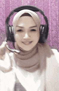 a woman wearing a hijab and headphones with a microphone .