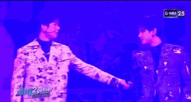 a couple of men standing next to each other with gmm on the screen