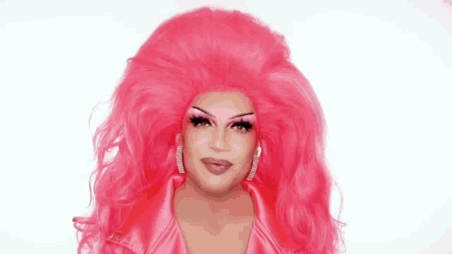 a drag queen is wearing a pink wig and a pink jacket