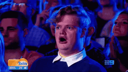 a man is making a funny face in a crowd of people .