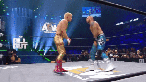 two men in a wrestling ring with the words all elite wrestling on the wall behind them