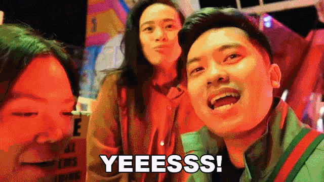 a group of people are posing for a picture and one of them says yeeesss !