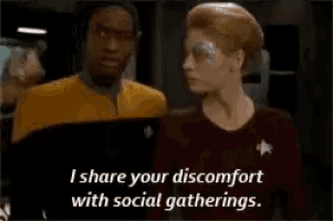 a man and a woman are standing next to each other and the woman says i share your discomfort with social gatherings .
