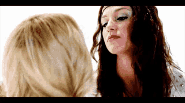 two women are looking at each other with a white background .