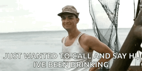 a man in a tank top and hat is standing on a boat .